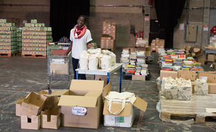 Aïcha, l'une des quatre fondatrices de l'association MaMaMa, préparant des colis alimentaires pour des mères isolées et leurs enfants.
