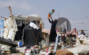 Une Palestinienne joue avec son enfant le 12 novembre 2014 dans un quartier de Gaza détruit durant les 50 jours de guerre contre Israël
