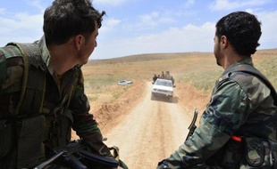 Syrian regime forces drive on May 9, 2015 near Assal al-Ward, a small regime-controlled village situated on the mountain of al-Kanissa in the Qalamun region, after they seized control of several hilltops in the mountainous area that straddles the Syria-Lebanon border with the support of Lebanon's Shiite Hezbollah movement. Pro-government forces have been battling rebel groups and Al-Qaeda affiliate Al-Nusra Front in the Qalamun region, which lies north of Damascus. AFP PHOTO / STR