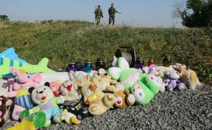 Des soldats prorusses passent à proximité d'un mémorial aux victimes du vol MH17, le 17 juillet 2016, sur le lieu du crash près du village de Grabove, dans l'est de l'Ukraine
