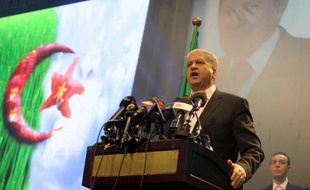 L'ex-Premier ministre algérien Abdelmalek Sellal devant un portrait géant d'Abdelaziz Boutefkika lors d'un meeting le 15mars 2014 à Alger