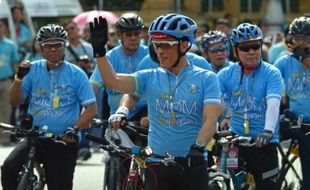 Le prince héritier de Thaïlande, Maha Vajiralongkorn, 63 ans, salue les spectateurs en prenant la tête d'une gigantesque opération cycliste en hommage à sa mère, la reine Sirikit, le 16 août 2015 à Bangkok