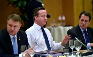 Le premier ministre britannique David Cameron (c) entre les présidents roumain Klaus Werner Iohannis (g) et chypriote Nicos Anastasiades (d) lors d'un dîner des dirigeants européens à Bruxelles le 19 février 2016