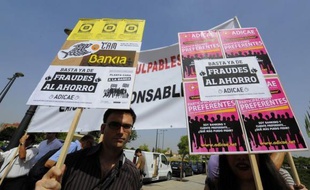 Des centaines d'actionnaires de Bankia qui ont perdu leurs économies sont arrivés furieux pour réclamer "des têtes", vendredi à leur première assemblée générale depuis l'annonce du sauvetage public de cette banque espagnole, pour plus de 23 milliards d'euros.