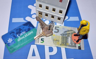 billet de 5 euros devant un emmeuble de location social