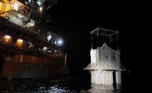 Le «couvercle» visant à colmater la fuite de pétrole qui s'écoule de la plate-forme Deepwater Horizon, au début de sa descente dans le Golfe du Mexique, au large des côtes de Louisiane, le 6 mai 2010.