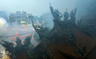 Les fidèles brûlent de l'encens et des offrandes lors d'une cérémonie taoïste au temple Matzu à Taichung, dans le centre de Taïwan, le 9 avril 2016