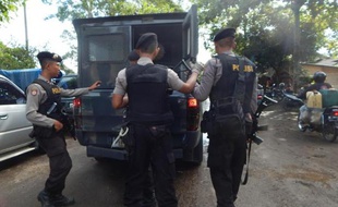 Le fourgon transportant l'un des condamnés à mort, arrive sous escorte policière le 24 avril 2015 à la prison de Nusakambangan sur l'île de Java