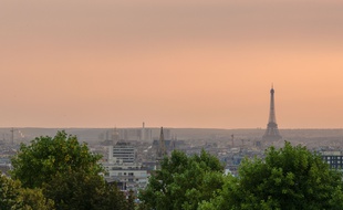 Le 23 juillet 2018, à Paris. Vue panoramique depuis le belvédère de Belleville lors d'un pic de pollution, à 21 heures juste après le coucher du soleil. A droite, la tour Eiffel; plus à gauche, on distingue le dôme des Invalides.