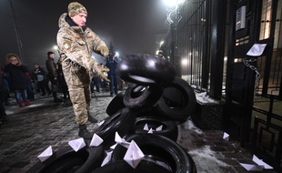 Un manifestant ukrainien jette un pneu devant l'ambassade russe à Kiev, après l'incident dans le détroit de Kertch, le 25 novembre 2018.