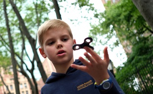 Un enfant joue avec une toupie «Hand Spinner» dans un parc de New-York.