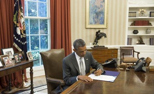 Le président américain Barack Obama signe un document prévoyant l'octroi de 225 millions de dollars supplémentaires à Israël pour le financement du Dôme de fer, le 4 août 2014 à la Maison Blanche