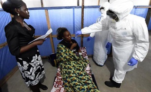 Des personnels de santé d'un centre de l'Organisation mondiale de la Santé à Monrovia auscultent une malade d'Ebola, le 3 octobre 2014