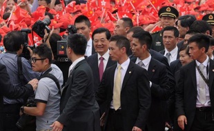 Chinese President Hu Jintao (C) smiles after arriving at Hong Kong's International airport on June 29, 2012. Hu Jintao arrived on June 29 ahead of an inaugaration ceremony for Hong Kong's new government and the 15th anniversary of the southern Chinese city's handover from Britain to China. AFP PHOTO / Dale de la Rey