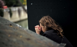 Une personne en prière près de Notre-Dame de Paris, le 16 avril 2019, au lendemain de l'incendie de la cathédrale. Illustration.