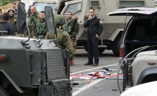Les forces de sécurité israéliennes inspectent la zone où trois Palestiniens ont été abattus le 14 mars 2016 après avoir attaqué des soldats, à l'entrée d'une colonie voisine de Hébron, dans le sud de la Cisjordanie occupée