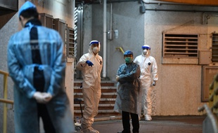 Du personnel médical attend près de l'entrée d'un lotissement résidentiel, à Hong Kong, le 11 février 2020, après que deux personnes dans le bloc ont contracté le coronavirus.