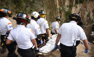 Des pompiers transportent un corps retrouvé dans les ruines du village d'El Cambray II, dans la municipalité de Santa Catarina Pinula, à 15 km à l'Est de Guatemala City, le 4 octobre 2015