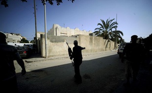 Un combattant rebelle patrouille dans un quartier rédisentiel de Tripoli, capitale de la Libye, le 22 août 2011.