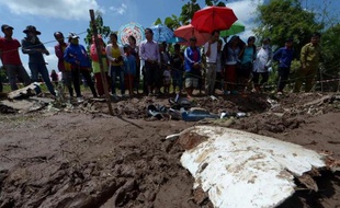Des villageois laotiens rassemblés près d'un débris de l'avion de Lao Airlines qui s'est abîmé dans le Mékong, le 17 octobre 2013