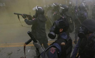 Des policiers dispersent des manifestants au gaz lacrymogènes lors d'une émeute anti-gouvernementale à Bangkok, Thaïlande.