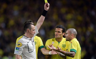 Frenc referee Rudy Buquet (L) gives a yellow card to Nantes' French midfielder Vincent Bessat (R) during the French L1 football match between Nantes and Paris Saint-Germain on May 3, 2015 at the Beaujoire stadium in Nantes, western France. AFP PHOTO / JEAN-SEBASTIEN EVRARD