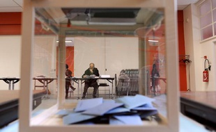Une personne lit un document en attendant les électeurs le 14 mars 2010 à Melle dans l'un des bureaux de vote installés pour le premier tour des élections régionales.