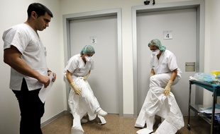 Two auxiliary nurses get dressed, aided by an instructor, with the individual protector suits to wear in case of possible ebola cases, during a clinical drill at La Fe Hospital in Valencia, eastern Spain, 13 October 2014. EFE/Juan Carlos Cardenas/EFE_148001/Credit:Juan Carlos Cardenas/EFE/SIPA/1410131438