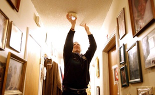 Photo d'illustration d'un homme installant un détecteur de fumée