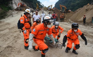 Des équipes de secours transportent le corps d'une victime après un glissement de terrain à Santa Catarina Pinula, le 6 octobre 2015 au Guatemala