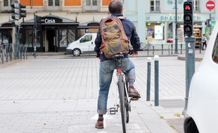 Un cycliste arrêté au feu rouge sur la place de Bretagne, à Rennes.