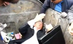 Capture d'écran d'une vidéo montrant le député ukrainien Vitaly Zhuravsky maintenu dans une poubelle par un groupe d'hommes en colère, le 16 septembre 2014 à Kiev.