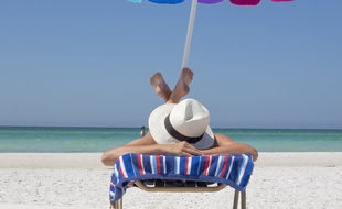 Illustration d'une personne bronzant au soleil, sous un parasol.