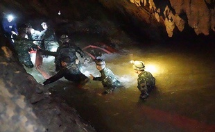 Les sauveteurs progressent dans la grotte où sont coincés 12 enfants en Thaïlande.