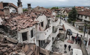 Des habitants dans les ruines de maisons détruites par les combats à Kumanovo, dans le nord de la Macédoine, le 11 mai 2015