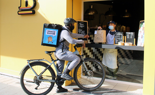 Un livreur Delicity récupère une commande chez un restaurant partenaire à Nice (Illustration)