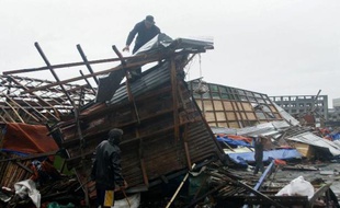 Un homme constate les dégâts sur sa maison détruite après le passage du typhon Hagupit, le 7 décembre 2014 à Tacloban, dans le centre des Philippines