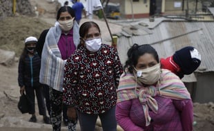 Des femmes attendent une distribution de nourriture, à Lima au Pérou le 27 mai 2020.
