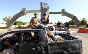 Des combattants islamistes de la coalition Fajr Libya montent la garde à l'entrée de l'aéroport de Tripoli le 24 août 2014