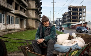 Un homme est assis dans sa charrette au milieu d'une rue de Zimnicea (130 km sud-est de Bucarest) ville ravagée par la pauvreté, 25 ans après la révolution roumaine