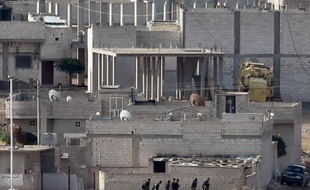 Des combattants kurdes marchent dans Kobané le 15 octobre 2014