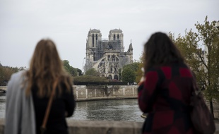 Des passantes devant Notre-Dame de Paris le 16 avril 2019 au lendemain de l'incendie qui a ravagé la cathédrale.