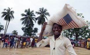 Un homme porte un sac du Programme alimentaire mondial à Dolo, au Libéria, le 2 septembre 2014.