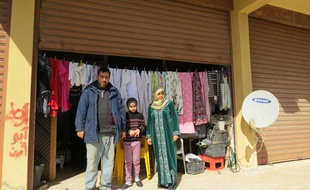 Ahmad, sa femme et sa fille devant le garage où ils vivent à Wadi Zeyni, au Liban, le 26 février 2015.