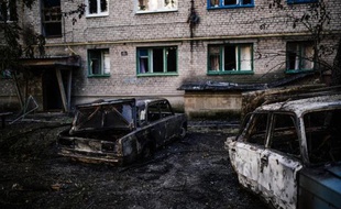 Des voitures carbonisées le 12 août 2014 après le bombardement de la ville de Yassynouvata, près de Donetsk, dans l'est de l'Ukraine