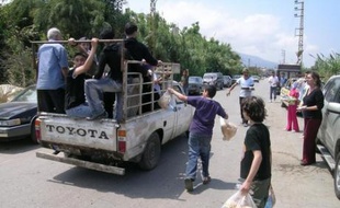 Les habitants du village voisin d'Al-Mina distribuent pain et eau du réfugiés palestiniens.