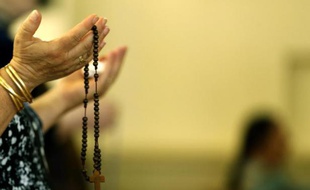 Une chrétienne irakienne, qui a fui les violences des villes Qaraqush et Bartala, à l'est de Mossoul,prie dans l'église Saint Georges le 1er juillet 2014 dans la région kurde autonome d'Erbil