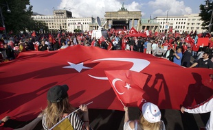Des manifestants tiennent un drapeau géant de la Turquie en face de la porte de Brandebourg à Berlin , Allemagne , le mercredi 1er Juin , 2016. Ils protestent contre une résolution du parlement fédéral allemand qui reconnait le génocide arménien.