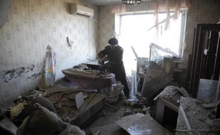 Une femme récupère des affaires à l'intérieur de son appartement dévasté par un bombardement, le 5 novembre 2014 à Donetsk, dans l'Est de l'Ukraine
