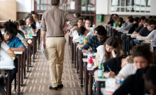 Un examinateur passe au milieu des candidats au baccalauréat lors de l'épreuve de philosophie le 16 juin 2011 à Paris